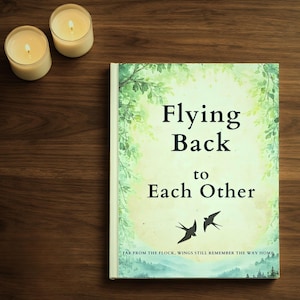 May include: A book titled "Flying Back to Each Other" with a green and white cover, featuring two flying birds. Two lit candles are on a dark wooden surface.