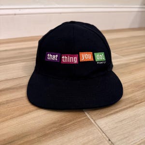 Vintage Nissin-pet uit 1996, promotiemateriaal voor de film That Thing You Do, zwart, met verstelbare band.
