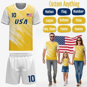 May include: Yellow and white athletic jersey and shorts set with the number 10 in blue. The jersey has the USA flag and text. The image also shows a family wearing matching shirts with the same design.