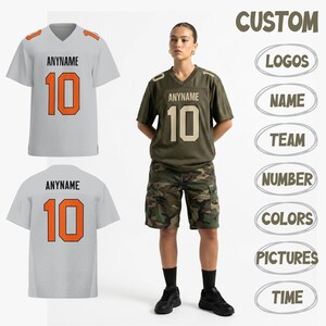 Peut inclure: Un maillot de football blanc et orange avec le texte "ANYNAME" et le numéro "10". Le maillot est présenté avec un maillot assorti et une personne portant un maillot vert avec le même texte et numéro. Le mot "CUSTOM" est en haut.