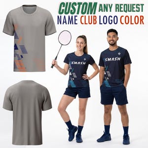 May include: Gray and navy blue athletic shirts and shorts with geometric designs. The shirts have the word "SMASH" printed on them. The image also includes the text "CUSTOM ANY REQUEST NAME CLUB LOGO COLOR". A badminton racket is also in the image.