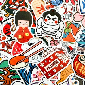 May include: A collection of assorted stickers featuring Japanese-themed illustrations including a kokeshi doll in a red kimono, a sumo wrestler, sushi with chopsticks, a red omamori charm with white text, a daruma doll, and a castle.