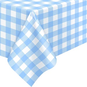 May include: A light blue and white checkered tablecloth. The fabric is folded over the corner of a table, showcasing the pattern. The pattern is a classic gingham design, with squares of light blue and white.