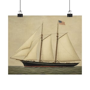 May include: A vintage print depicting a three-masted schooner at sea. The ship features white sails, a black hull with a red stripe, and an American flag. The artwork is held in place with black binder clips.