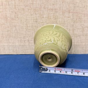 以下が含まれることがあります： 淡い緑色のセラミックカップ、花柄。 カップの直径は約7.6cm、高さは6.3cmです。 金属製の巻尺がカップの隣にあります。