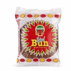 Puede incluir: Un bollo especiado empaquetado. El bollo es redondo y marrón, visible a través de un envoltorio de plástico transparente. El embalaje presenta un diseño de estrella roja y amarilla con las palabras "Spiced Bun" en amarillo y el logotipo de la marca. Peso neto: 125 g.