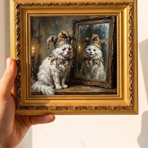 May include: A square gold-toned ornate frame containing a painting of a white long-haired cat wearing a jester hat and collar with a red clown nose and blue tear makeup, sitting beside a mirror reflecting the cat with a smiling clown face.