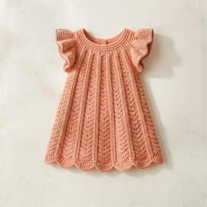 May include: A peach-colored, knitted dress with a scalloped hem and ruffled sleeves. The dress features a textured, vertical pattern and a round neckline. The dress is designed for a child.