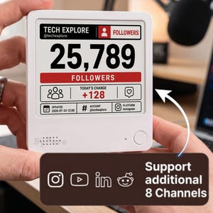 May include: A white digital follower counter device with a square screen displaying 25,789 followers for Tech Explore on Instagram. The screen shows today's change of +128, a date of 2026-07-24, and a graphic indicating support for 8 additional channels.