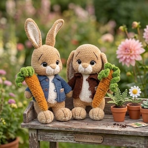 May include: Two crocheted bunny dolls, each holding a carrot. One wears a blue jacket, the other a brown jacket. They sit on a wooden bench with potted plants and flowers in a garden setting.
