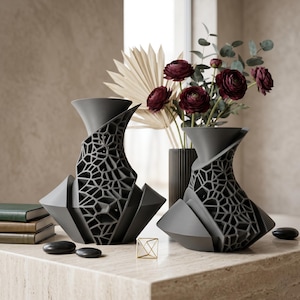 Puede incluir: Un juego de tres tazas de cerámica con un esmalte moteado de color crema. Cada taza presenta un diseño pintado a mano diferente: una hoja azul y verde, una flor amarilla y una baya roja. Las tazas tienen una forma simple y redondeada.