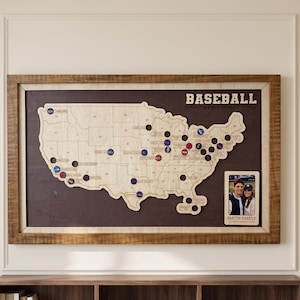 May include: A framed wooden map of the United States featuring a baseball theme with the text BASEBALL MAJOR LEAGUE. The map includes circular cutouts for markers and a small rectangular frame for a photograph labeled SMITH FAMILY at the bottom.
