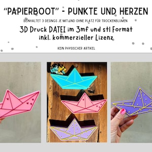Pode incluir: A imagem mostra três designs coloridos de barcos de papel em rosa, azul e roxo. Cada barco apresenta um padrão único de pontos e corações. O texto na parte superior diz "PAPIERBOOT" - PUNKTE UND HERZEN, com detalhes sobre o arquivo de impressão 3D.