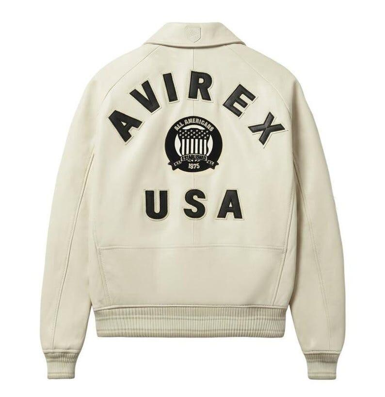 Back view of Avirex Jacket Men leather varsity style jacket featuring large “AVIREX USA” lettering and embroidered All Americans crest logo on the back. This bold Men Avirex Jackets design includes ribbed white striped cuffs and hem, premium leather construction, and classic bomber fit inspired by Avirex heritage style.