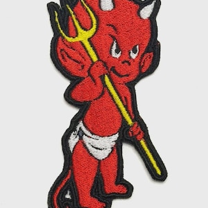 May include: Embroidered patch featuring a cartoon devil in red with white horns and a yellow pitchfork. The devil is wearing a white diaper and has a black border. This patch is suitable for jackets, bags, or other fabric items.