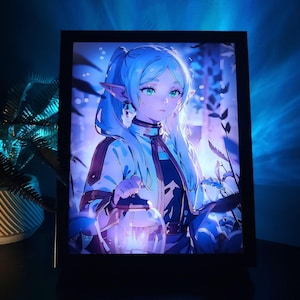 Può includere: Illustrazione incorniciata in stile anime di un personaggio con capelli blu e orecchie a punta, che tiene in mano una lanterna. L'opera presenta una morbida tavolozza di colori blu e viola, con una dettagliata raffigurazione dei vestiti e dei lineamenti del personaggio. La cornice è nera.