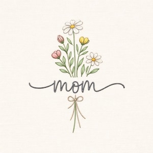 Puede incluir: Diseño floral bordado con la palabra "mamá" en escritura cursiva. El ramo presenta margaritas, capullos y flores amarillas con hojas verdes. Un pequeño lazo está debajo de la palabra "mamá".
