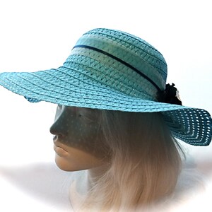 May include: A light blue straw sun hat with a wide brim and a black ribbon.