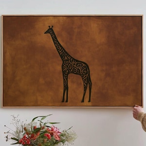 May include: A rectangular wall art piece featuring a black silhouette of a giraffe with intricate, swirling patterns inside its body. The artwork is set against a textured, solid brown background and is enclosed in a light-colored wooden frame.