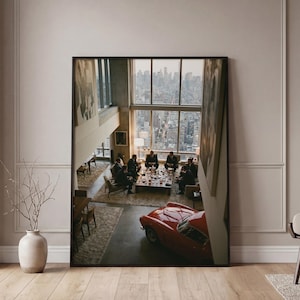 May include: A framed print depicts a high-angle view of a meeting in a modern apartment with a city skyline visible through large windows. A red vintage car is parked in the foreground. Men in suits are seated around a table.