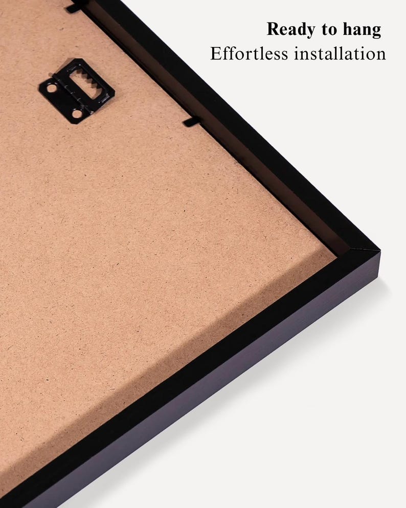 May include: Close-up of a black picture frame with a brown backing. The frame has a hanging bracket attached. Text on the image reads "Ready to hang" and "Effortless installation".