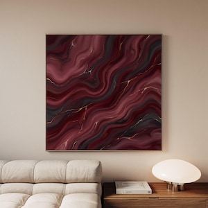 May include: A square wall art piece featuring an abstract fluid design with swirling patterns of deep burgundy, dark charcoal, and black, accented by thin, delicate veins of metallic gold throughout the composition, framed in a thin metal border.