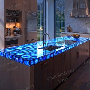 May include: A kitchen island featuring a glowing blue agate stone countertop with a polished finish. The island includes a built-in stainless steel sink and faucet, set against a backdrop of wooden cabinetry and a modern kitchen interior design.