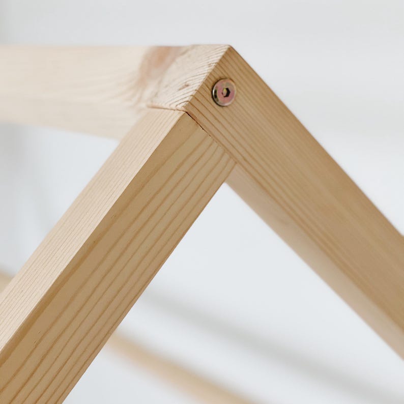 May include: Close-up of a wooden frame with a screw securing two pieces of wood together.