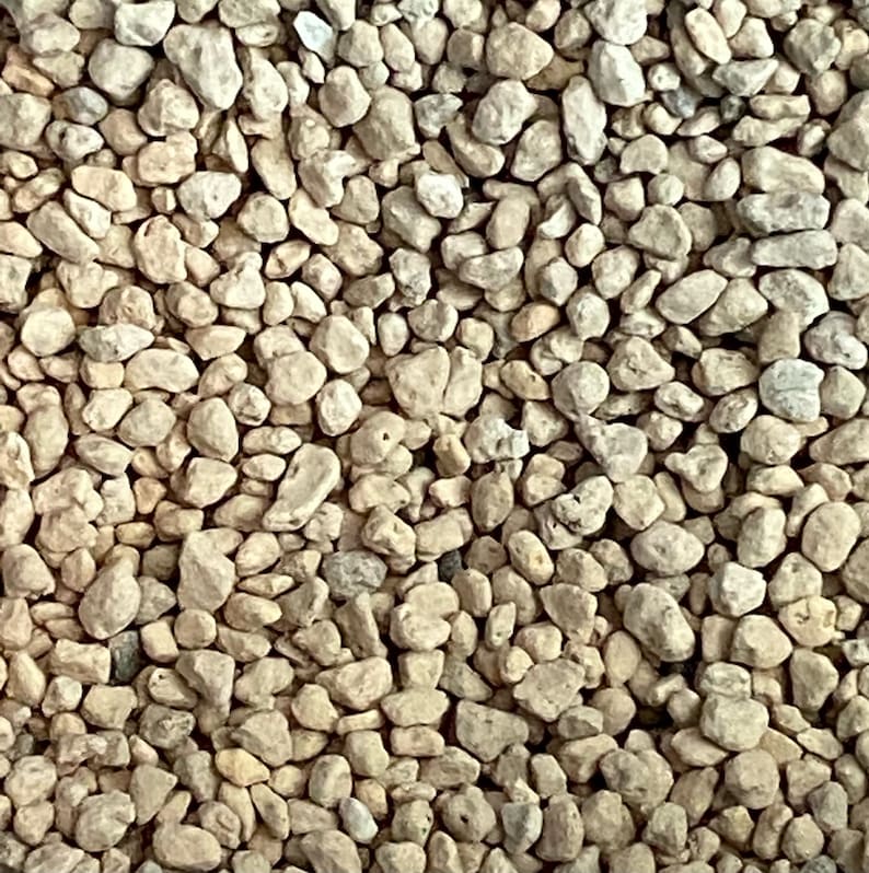 K&ouml;nnte beinhalten: Ein Nahaufnahmebild von kleinen, hellbraunen, unregelm&auml;&szlig;ig geformten Steinen. Die Steine sind glatt und haben ein nat&uuml;rliches, erdiges Aussehen.