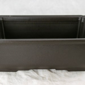 May include: A dark brown rectangular plastic bonsai pot with a slightly flared rim and a flat base.