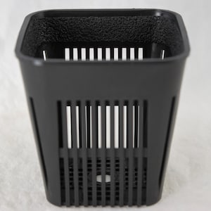 May include: A black square-shaped plant pot with vertical and horizontal slits for drainage. The top rim has a textured surface. The pot is designed for hydroponic gardening and is made of durable plastic.