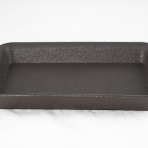May include: A dark brown plastic rectangular tray with a textured surface.