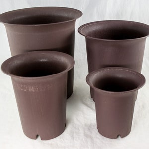 May include: Four brown plastic plant pots of different sizes. The pots are all round and have a smooth, textured surface.