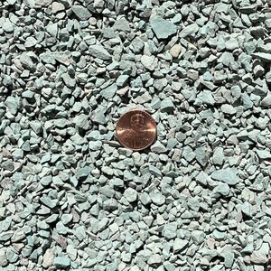 K&ouml;nnte beinhalten: Nahaufnahme von gr&uuml;nem Erbsenkies, mit einem Penny als Gr&ouml;&szlig;envergleich. Der Kies ist klein und gleichm&auml;&szlig;ig in der Gr&ouml;&szlig;e.