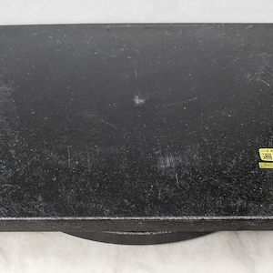 May include: A black, square, rotating turntable with a label that reads "黒檀台" in Japanese. The label is gold and has a black border.