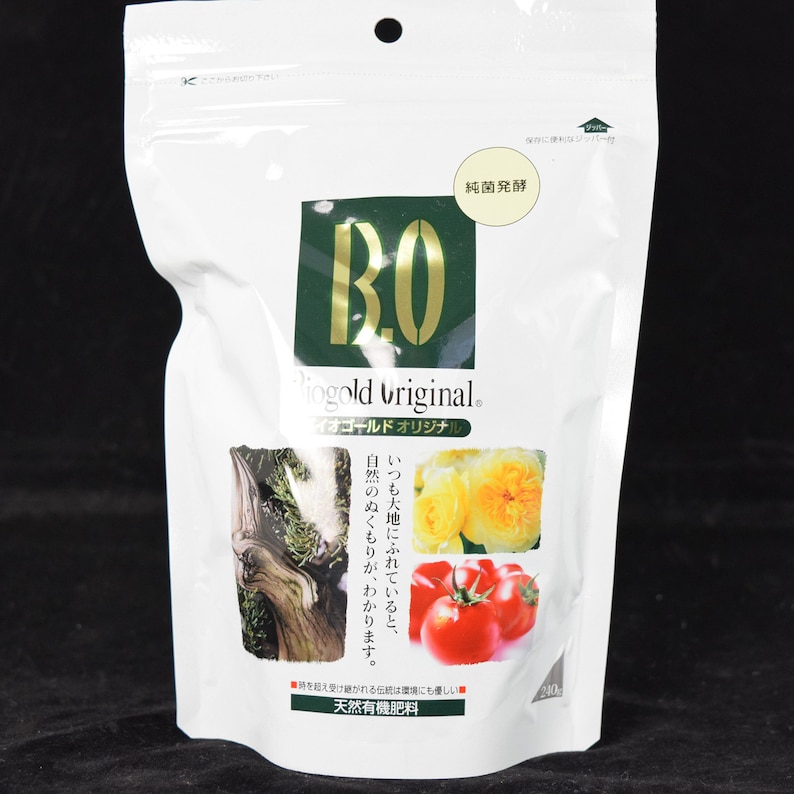 May include: A white pouch with a green and gold logo that says "BO Pingold original. イオゴールドオリジナル."  The pouch has a zipper closure and the text "純菌発酵" in a white rectangle. The pouch is filled with a brown granular fertilizer.