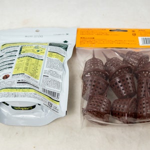 May include: Two packages of gardening supplies. One package contains brown plastic plant pots with a grid pattern. The other package contains a bag of fertilizer with Japanese text and a barcode.