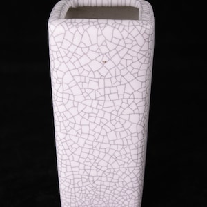 May include: White ceramic square vase with a crackle glaze finish. The vase has a square base and a rectangular body.