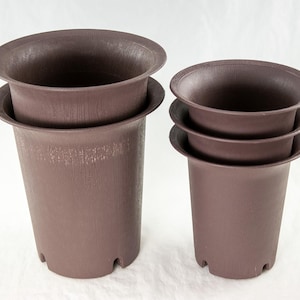 May include: Four brown plastic plant pots of different sizes, stacked on top of each other. The pots have a textured surface and a slightly flared lip.