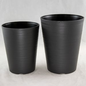 May include: Two black plastic plant pots with a textured finish. The larger pot is taller than the smaller pot.