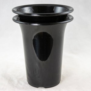 May include: Two black plastic flower pots stacked on top of each other. The pots are smooth and shiny.
