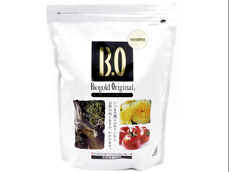 May include: White bag with a black and gold logo that says "BO Biogold Original." The bag has a picture of a tree, roses, and tomatoes. The text "特許純菌発酵" is in a circle on the bag. The text "天然有機肥料" is at the bottom of the bag.