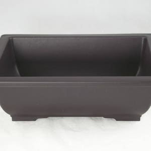 May include: A dark brown rectangular bonsai pot with a slightly curved design. The pot has a square shape with a flat rim and sits on four small feet. The interior is a deep, dark color.