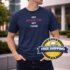May include: Navy blue t-shirt with the text "404 MOTIVATION NOT FOUND" in red and white. The shirt is a short-sleeved crew neck style. The image also includes a "FREE SHIPPING" graphic.