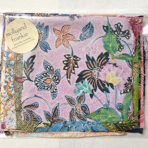 May include: A stack of fabric squares with a floral pattern in shades of pink, green, blue, and brown. The fabric squares are packaged in a clear plastic bag with a label that reads "mollyand frankie Byron Bay, Australia mollyandfrankie.store on Etsy".