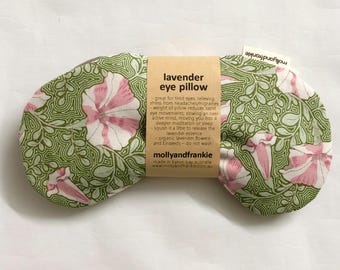 May include: A green and pink floral eye pillow with a brown label that reads "lavender eye pillow". The label describes the benefits of the pillow, including relieving stress, headaches, and migraines. The label also states that the pillow is made in Byron Bay, Australia, and is made by Mollyandfrankie.