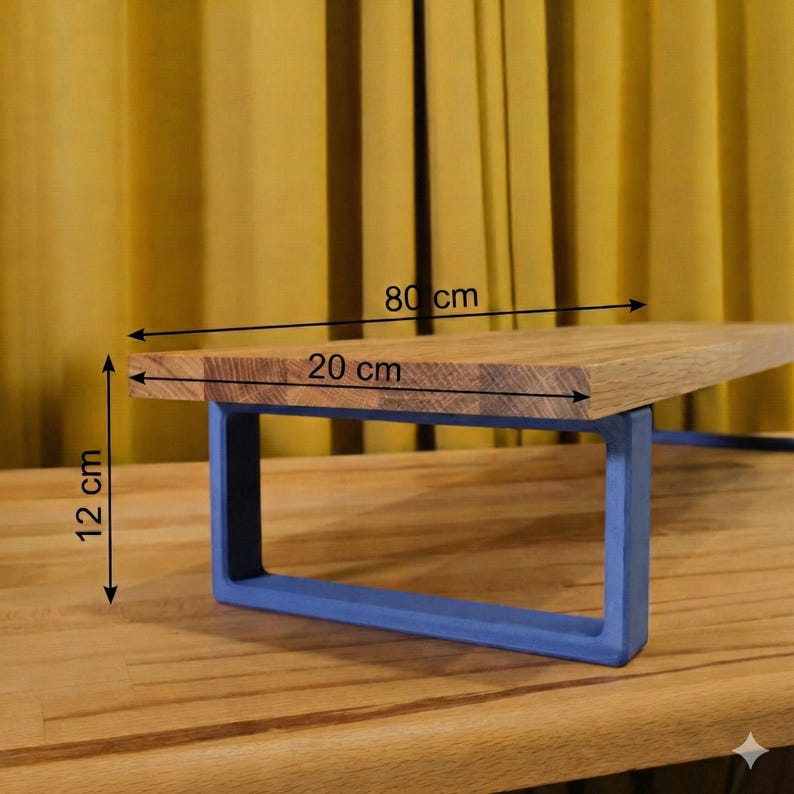 May include: A wooden shelf with a blue metal frame. The shelf measures 80 cm long, 20 cm wide, and 12 cm high. The wood has a natural grain, and the frame is a solid blue colour. The shelf is designed for display or storage.