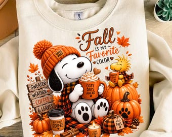 Puede incluir: Una sudadera color crema con un gráfico de Snoopy con gorro naranja, sosteniendo una taza naranja con la etiqueta 'COZY DAYS AHEAD'. El texto dice 'Fall IS MY Favorite COLOR', 'SWEATER WEATHER COFFEE & LEAVES', 'BUT FIRST COFFEE' y 'STAY COZY'.