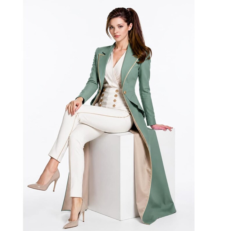 May include: A sage green long-line blazer with gold piping and a single button closure, paired with high-waisted white trousers featuring gold buttons and a matching white wrap-style blouse. The ensemble is completed with beige high-heeled pumps.