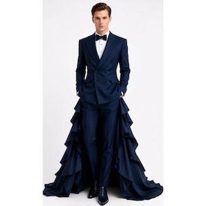 May include: A dark navy blue double-breasted suit featuring a crisp white dress shirt, a dark bow tie, and matching trousers. The suit jacket is extended with a dramatic, floor-length train composed of multiple layers of cascading fabric ruffles.